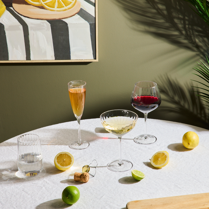 Bravo Still Wine Glass Set - 2pc - Clear, sleek clear stemware styled with drinks and citrus on a sunlit table.
