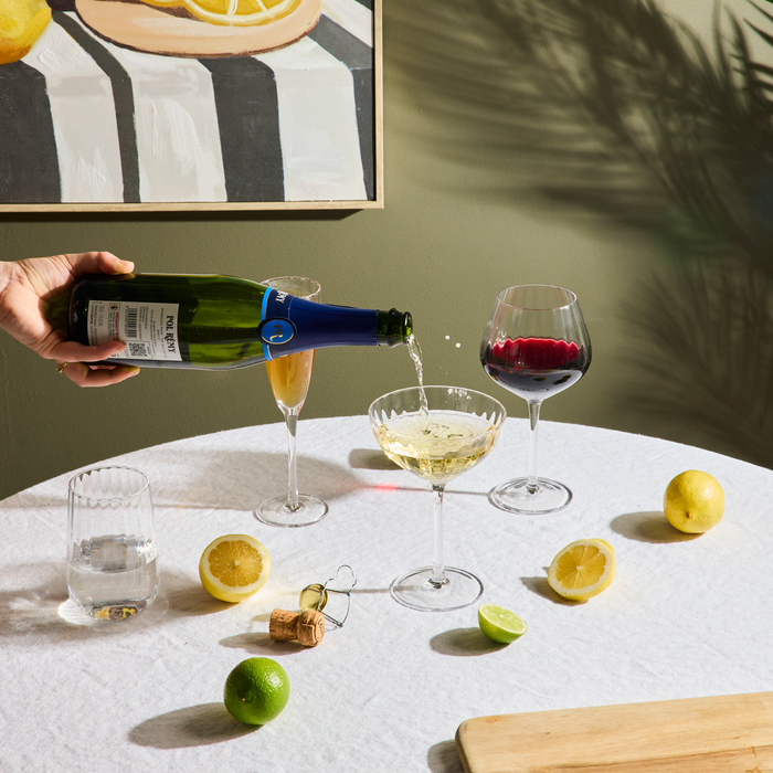 Bravo Tall Tumbler Set - 2pc - Clear, clear ribbed glass tumbler styled with wine glasses, sparkling wine and citrus on a table.