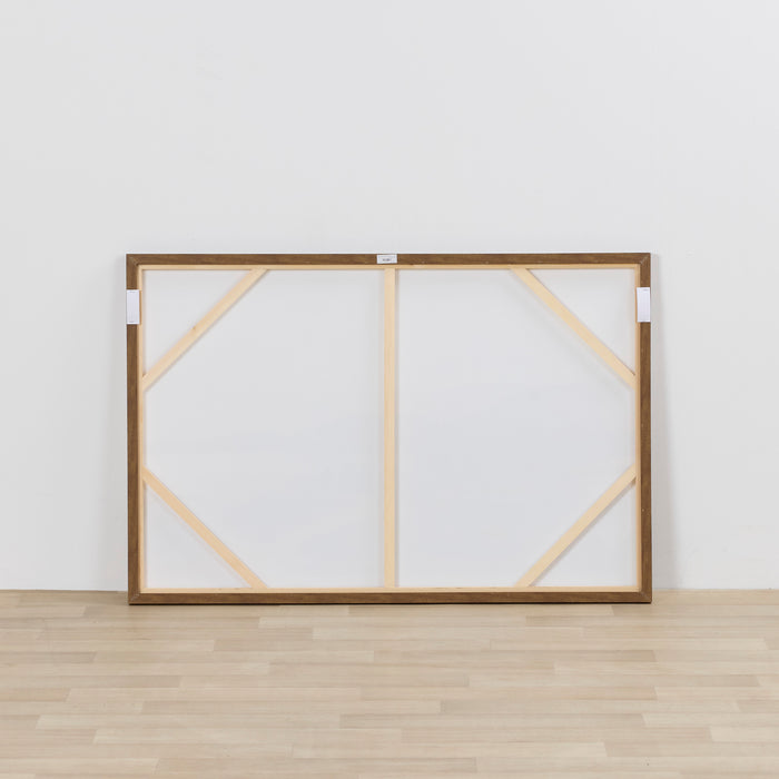Large wooden picture frame with geometric design on a white wall.
