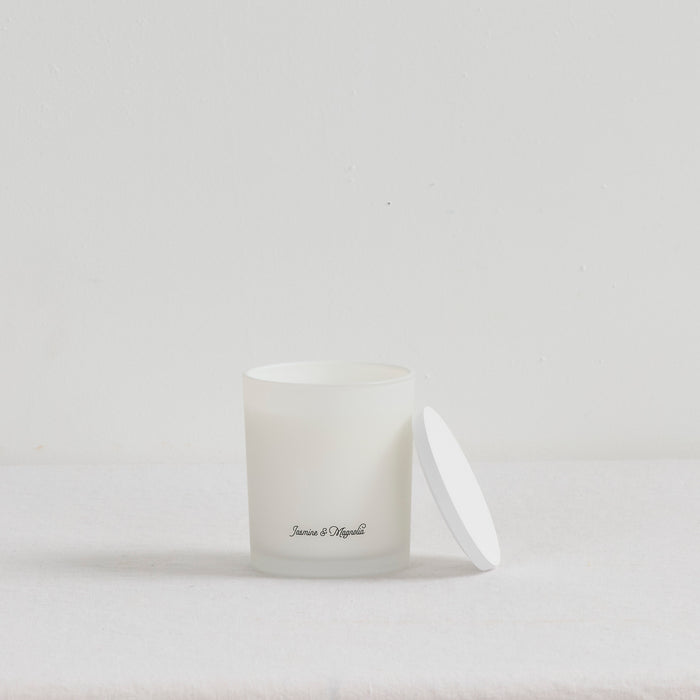 The Scent Collective Candle - Jasmine and Magnolia, white glass home fragrance candle with lid beside it