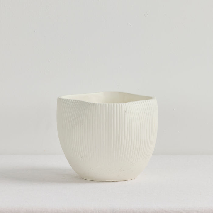 White ceramic cup with textured surface on a light gray background
