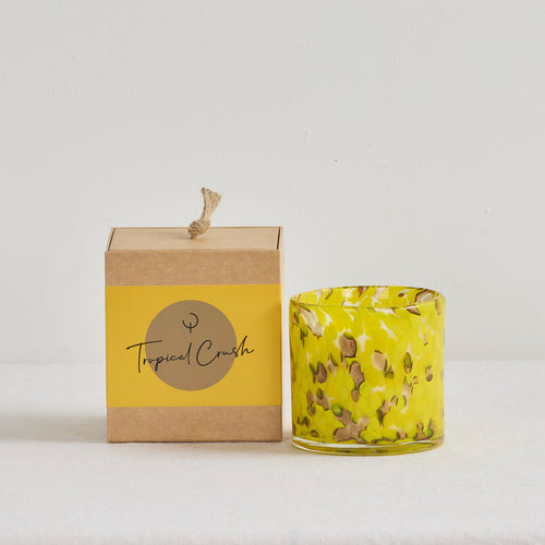 Aurora Candle - Tropical Crush scented candle in a mottled yellow glass vessel beside its kraft gift box