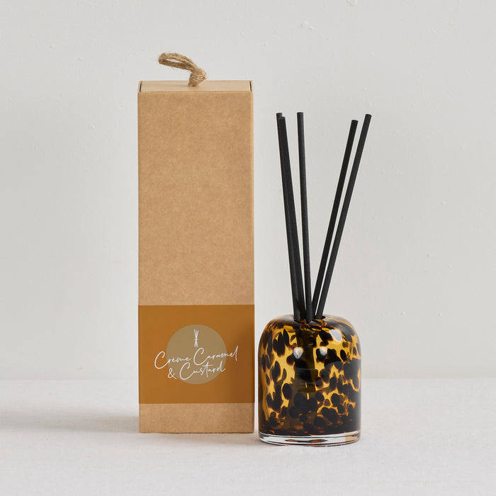 Aurora Diffuser - Crème Caramel & Custard reed diffuser in a tortoiseshell glass vessel beside kraft gift box