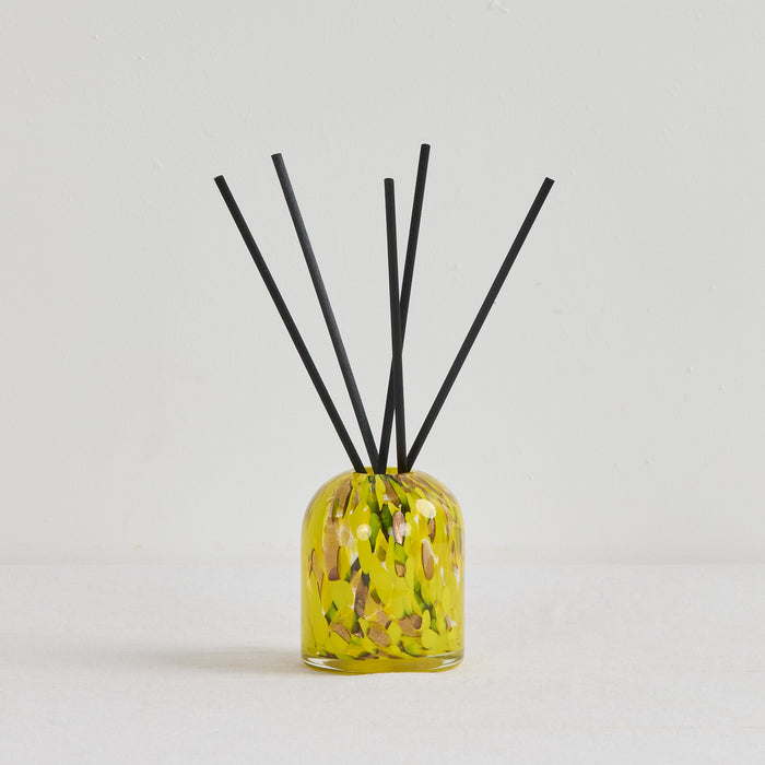 Aurora Diffuser - Tropical Crush reed diffuser in a mottled yellow glass vessel with black reeds