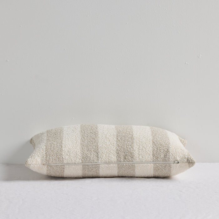 Benton 30x50cm Cushion - Natural Stripe, textured neutral striped cushion with visible zip closure on a white bed.