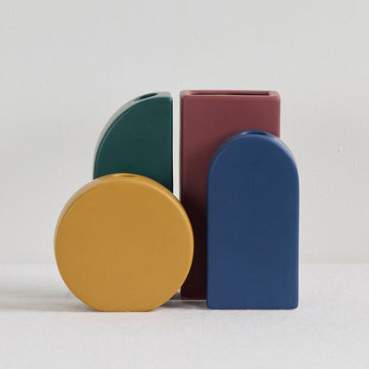 Block Vase - Port, rich port rectangular sculptural decorative vase displayed alongside blue, green and yellow contemporary vases