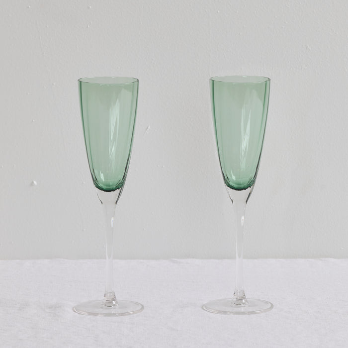 Bravo Champagne Glass Set - 2pc - Green, two sleek soft green glass champagne flutes with clear slender stems.