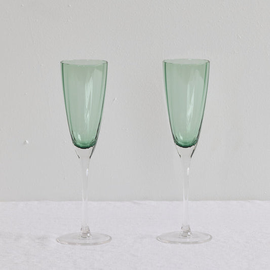 Bravo Champagne Glass Set - 2pc - Green, two sleek soft green glass champagne flutes with clear slender stems.