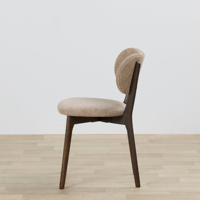 Beige chair with wooden legs on a light wood floor and white wall background