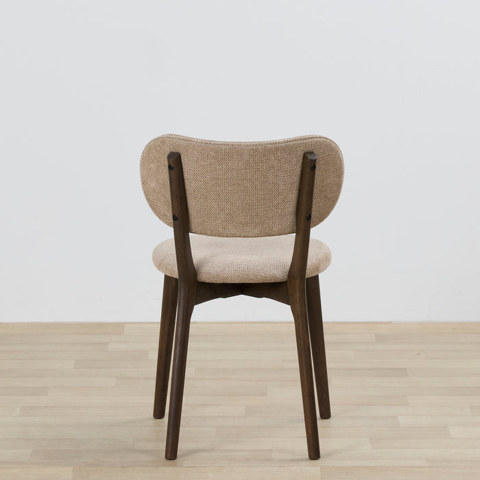 Chair with beige cushioned seat and backrest on a wooden floor with a light gray background