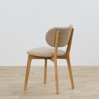 Chair with wooden frame and beige cushioned seat and backrest on a light wooden floor.