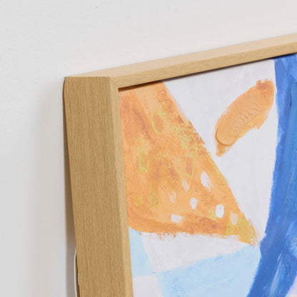 Close-up of a framed abstract painting with a wooden frame.