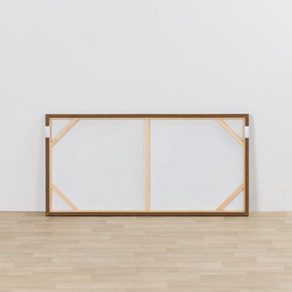 Wooden picture frame with glass on a white wall