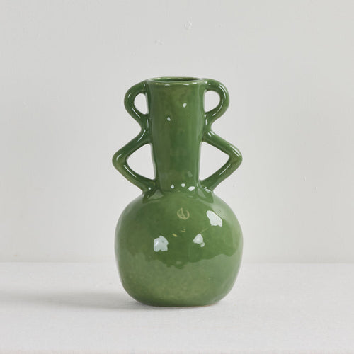 Green ceramic vase with two handles on a light gray background
