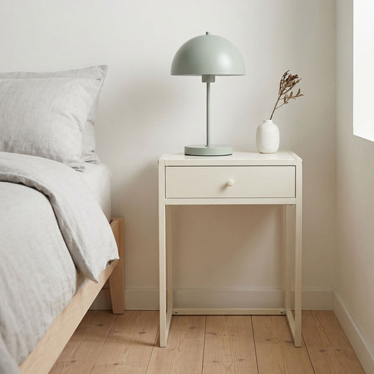 Minimalist bedroom with a nightstand, lamp, and vase.