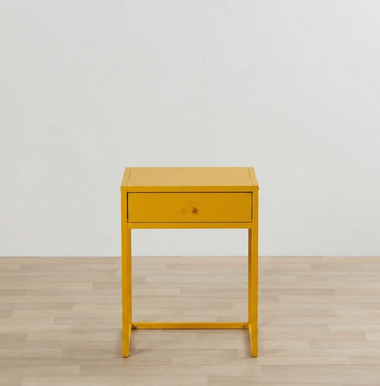 Yellow side table with a drawer on a wooden floor and light gray wall background