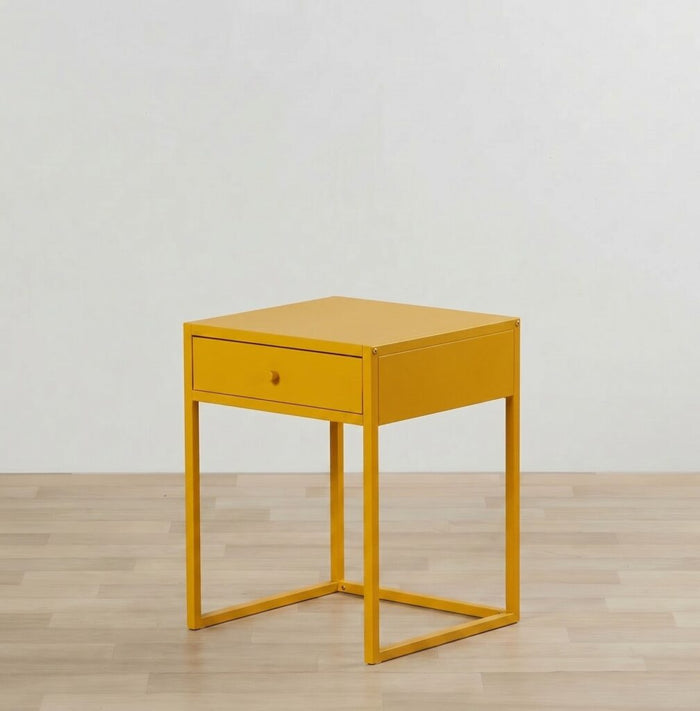 Yellow side table with a drawer on a wooden floor and light gray wall background
