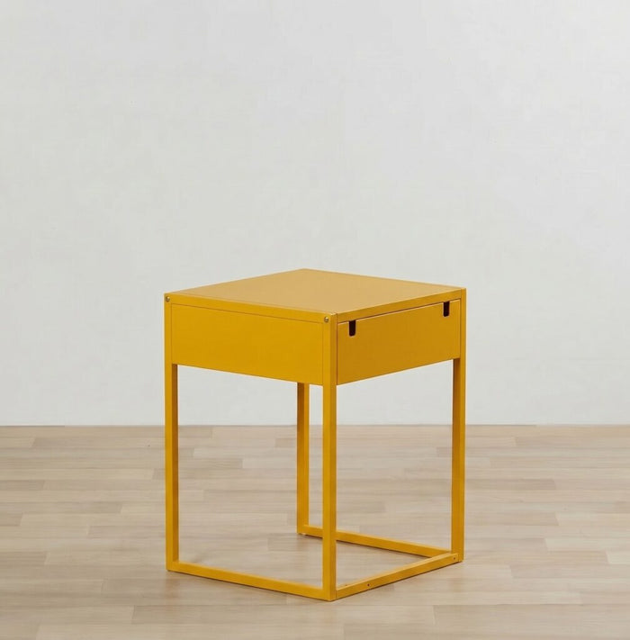 Yellow side table with a drawer on a wooden floor and light gray wall background