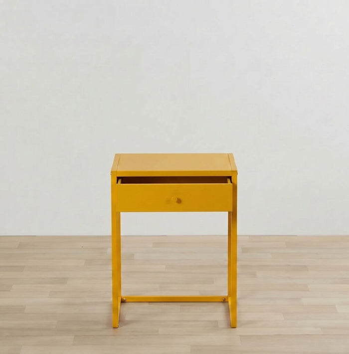 Yellow side table with a drawer on a wooden floor and light gray wall background