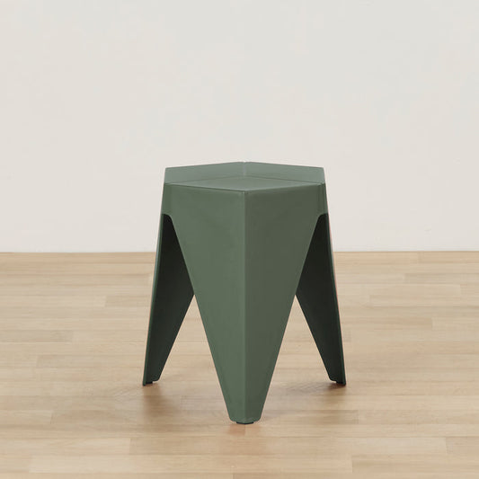 A dark green hexagonal plastic stool with a geometric, angular design, standing on a light wood floor against a plain off-white wall.