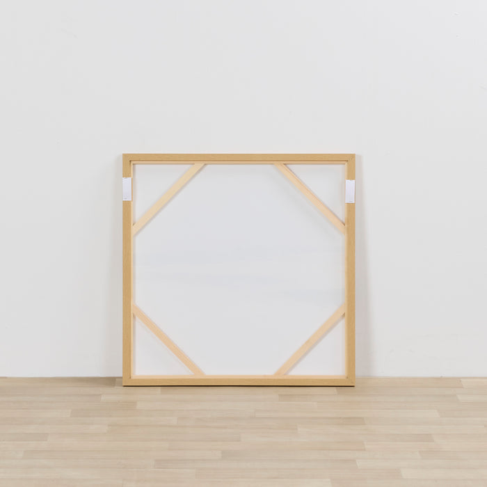 Wooden picture frame on a white wall with wooden floor