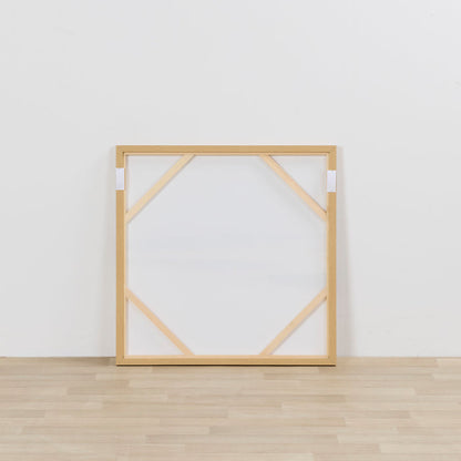 Wooden picture frame on a white wall with wooden floor