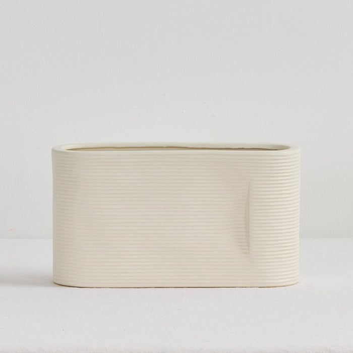 Linea Low Vase - Bone, low wide ribbed ceramic vase with a softly rounded rectangular silhouette and neutral finish