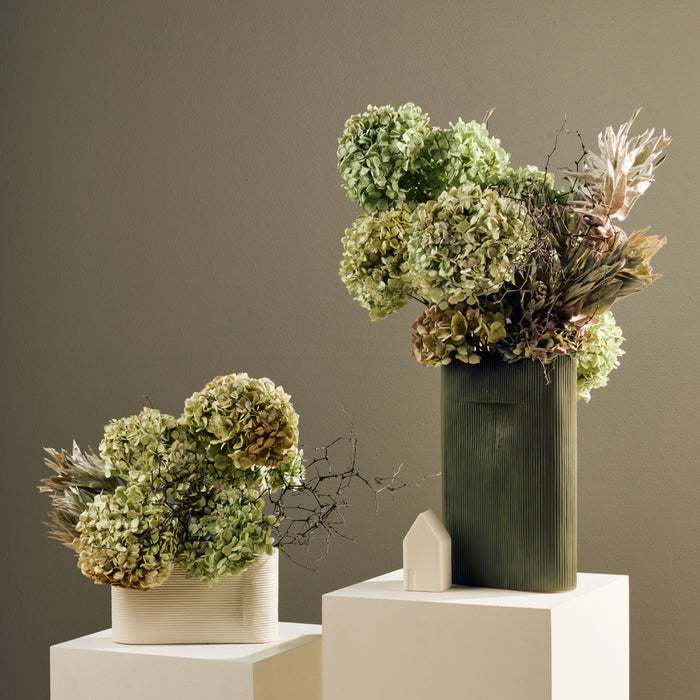 Linea Low Vase - Bone, low wide ribbed ceramic vase styled with dried greenery beside a tall green vase