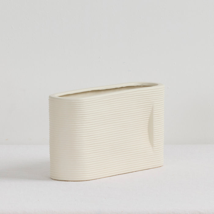 Linea Low Vase - Bone, low wide ribbed ceramic vase with a softly rounded oval silhouette and neutral bone finish