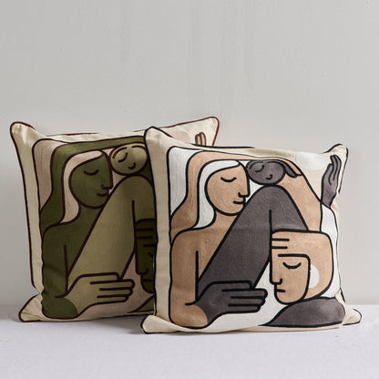 Two decorative throw pillows with an abstract minimalist illustration of figures in muted green, beige, cream, and dark gray tones, set against a plain light gray background.