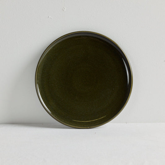 Green dinner plate on a white table cloth
