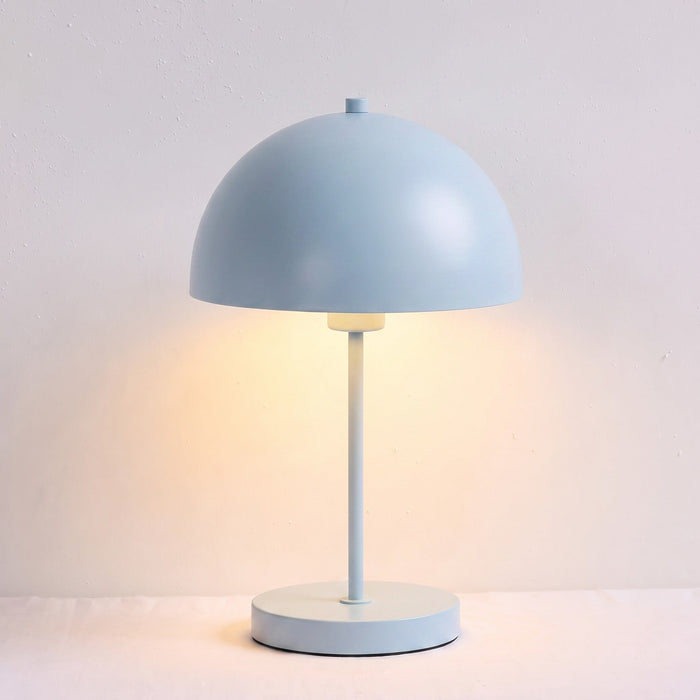 A light blue dome-shaped table lamp with a matching round base and stem, shown lit against a soft off-white background.