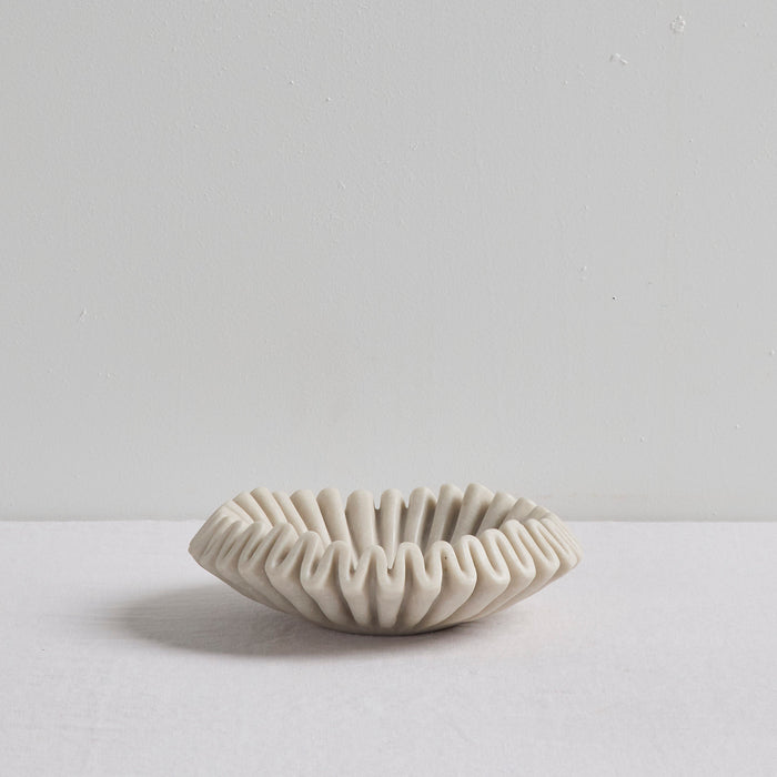 Ruffled Bowl - Bone, sculptural bone-coloured decorative bowl with a ruffled silhouette on a white surface