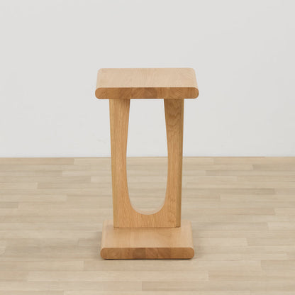 Samson End Table - Oak side table with a rounded oak top, sculptural U-shaped base and plinth foot on timber flooring