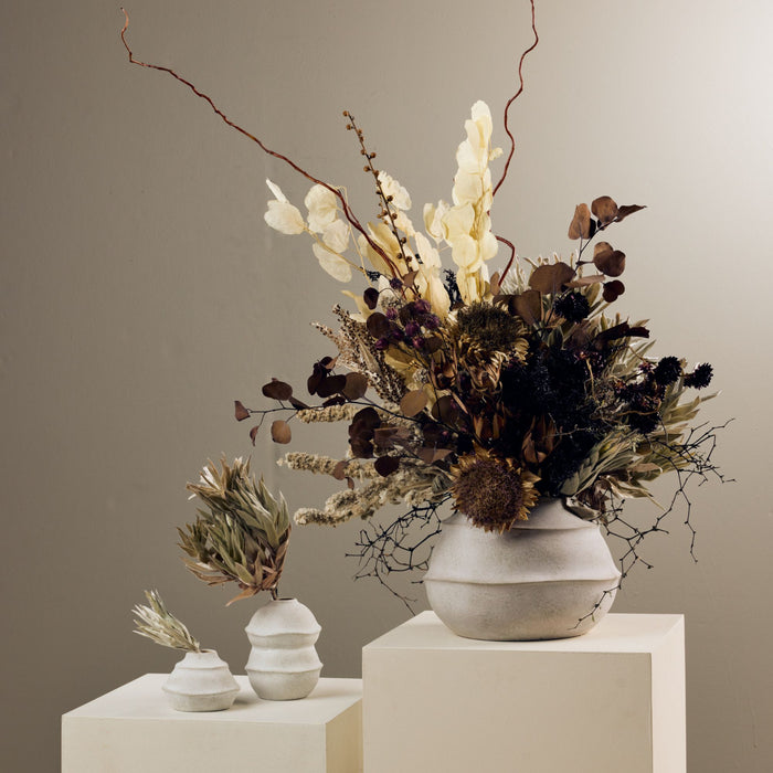 Sculptural Medium Ornament - Cement, rounded tiered cement ornament styled with dried floral branches