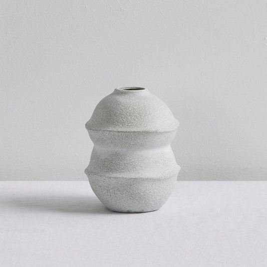 Sculptural Small Ornament - Cement, small textured stoneware ornament with a tiered rounded silhouette on a white surface