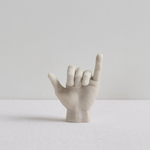 Shaka Hand Object - Bone sculptural ornament in a playful hang loose hand gesture on a white surface