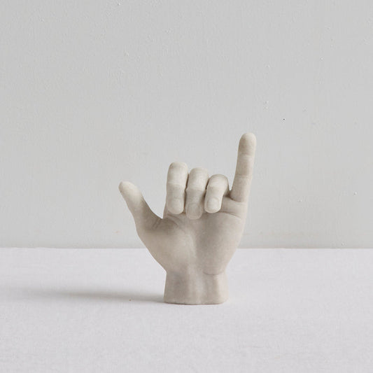 Shaka Hand Object - Bone sculptural ornament in a playful hang loose hand gesture on a white surface