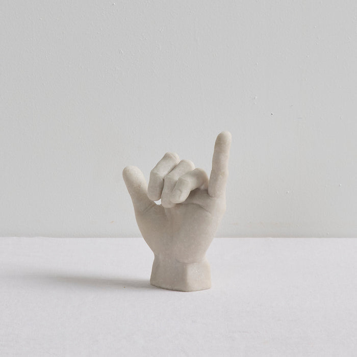Shaka Hand Object - Bone sculptural hand ornament in a hang loose gesture, displayed on a white surface