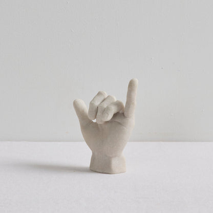 Shaka Hand Object - Bone sculptural hand ornament in a hang loose gesture, displayed on a white surface