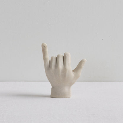 Shaka Hand Object - Bone sculptural hand ornament in a hang loose gesture on a white surface