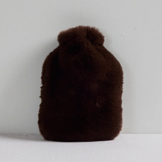 Brown fluffy hot water bottle on a light gray background