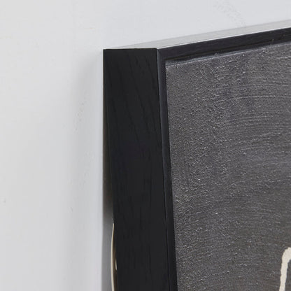 Close-up of a black framed picture on a white wall