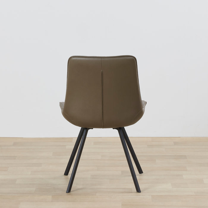 Brown chair with black legs on a wooden floor and light gray wall background