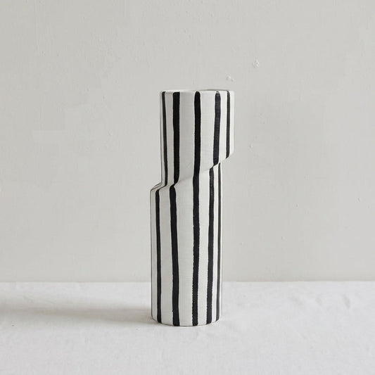 Black and white striped vase on a light gray background