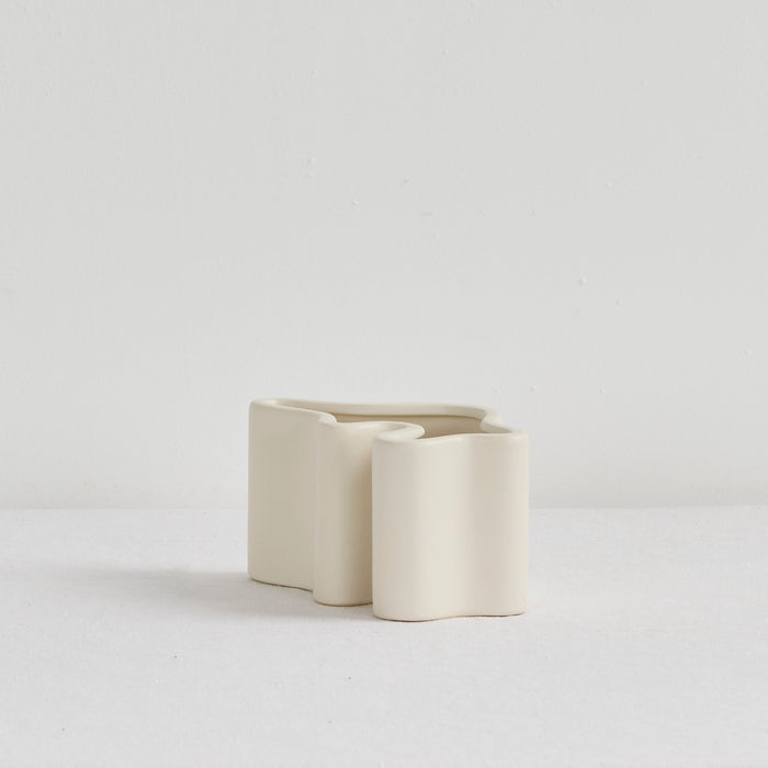 Wave Low Vase - Bone, low sculptural ceramic vase with softly curved interlocking forms in a bone finish