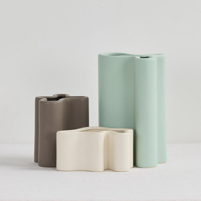 Wave Low Vase - Bone, low sculptural ceramic vase with softly undulating form, styled alongside taller vases